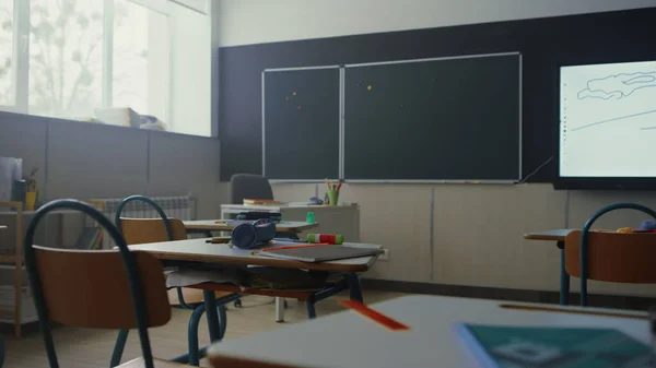 Sala de aula com quadro-negro. Mesas escolares e cadeiras com suprimentos — Fotografia de Stock
