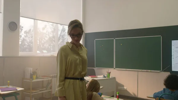 Profesor caminando en el aula con niños. Estudiantes haciendo test en clase —  Fotos de Stock