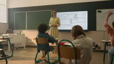 Öğretmenler çocuklara ders veriyor. İlkokulda okuyan öğrenciler