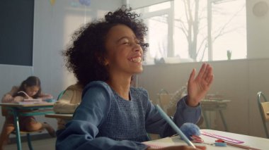 Gülümseyen öğrenci derste el kaldırıyor. Gülen liseli kız soruya cevap veriyor