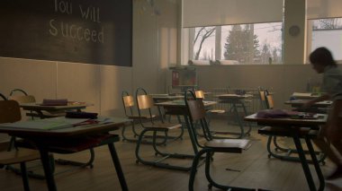 Ders için sınıfta koşan öğrenciler. Sınıfta çok ırklı öğrenciler konuşuyor