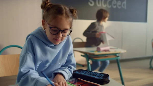 Criança focada estudando em classe. Menina inteligente escrevendo em notebook na lição — Fotografia de Stock