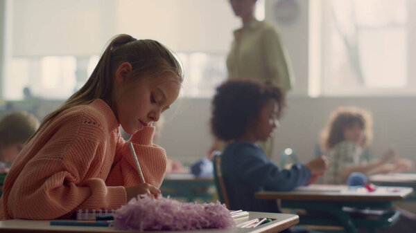 Girl writing test in classroom. Smart student making notes in exercise book 