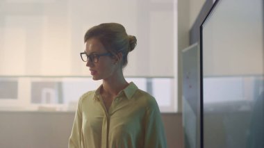 Sınıfta duran bir bayan öğretmen. Genç öğretmen dersi açıklıyor.