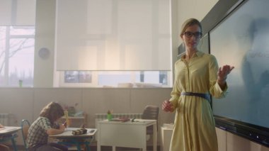 Öğretmen açıklama dersi. Etkileşimli dijital beyaz tahta üzerinde kız çizim görevi