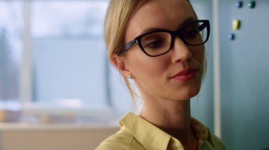 Sınıfta duran bir öğretmen. Gülümseyen öğretmen oditoryum dersini açıklıyor