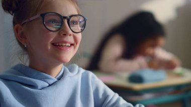 Sınıfta öğretmenle konuşan bir kız. Öğrenci derste şiir okuyor.