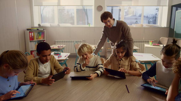 Students doing class work on digital tablets. Pupils using tablet computers