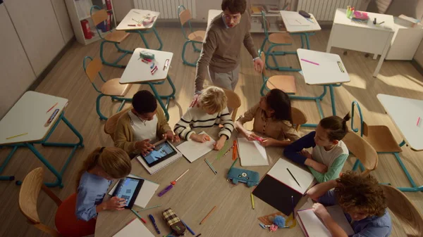 丸いテーブルで勉強パッド付きの人形。デジタルタブレットを使用する子供たち — ストック写真