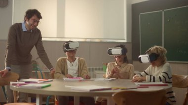 Öğretmenim sınıfta 3D VR gözlüklü öğrencilerle etkileşimli ders alıyor.