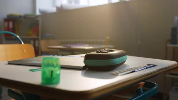 Material escolar en el escritorio en el aula. Cuaderno y bolígrafos acostados en la mesa — Vídeos de Stock