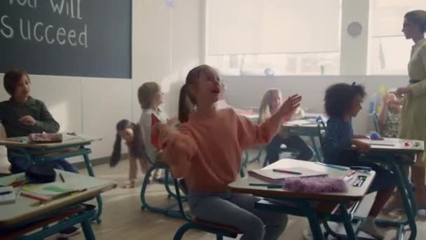 Bambini che si divertono in classe. Pupille di razza mista che giocano con aerei di carta — Video Stock