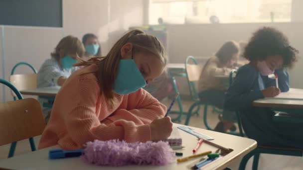 Menina inteligente na escola máscara médica em sala de aula durante a pandemia de coronavírus — Vídeo de Stock