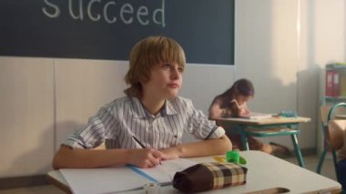 Öğrenci not defterine not alıyor. Akıllı çocuk derste alıştırma kitabına yazıyor.