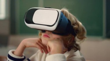 Derste 3D VR gözlük takan bir çocuk. Sanal gerçekliğe dalan öğrenci.