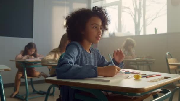 Enfant étudiant en sciences à l'école primaire. Fille assise au bureau dans la classe — Video