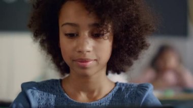 Sınıfta masa başında oturan bir kız. İlkokulda düşünceli öğrenci öğrenimi