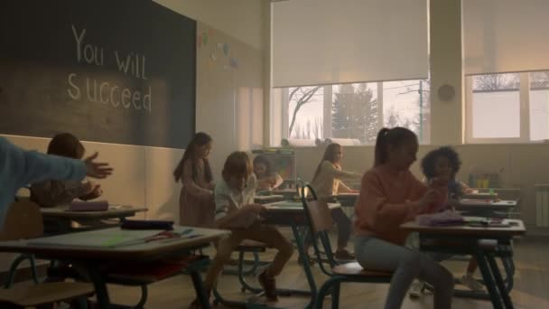 Studenten leren in de klas. Schooljongens en schoolmeisjes die aan een bureau zitten — Stockvideo