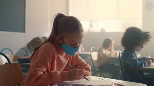 Μαθητής με προστατευτική μάσκα που σπουδάζει στο σχολείο κατά τη διάρκεια πανδημίας του ιού του στέμματος — Αρχείο Βίντεο