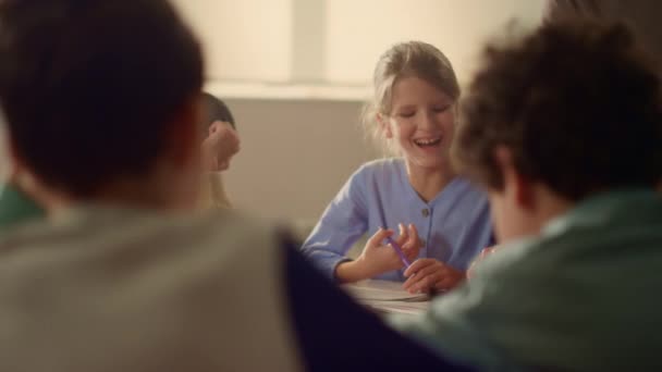 Les enfants apprennent à table ronde en classe. Elèves qui travaillent en classe à l'école — Video