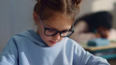 Okulda düşünceli kız öğreniyor. Not defterine yazan düşünceli öğrenci.