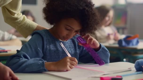 Estudiante haciendo trabajo de clase en el escritorio. Profesora ayudando a chica con la tarea de la lección — Vídeos de Stock