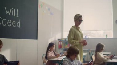 Derste öğretmen arayan öğrenciler. Dijital tabletlerle öğrenen çocuklar