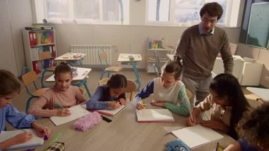 Okulda fen bilgisi okuyan öğrenciler. Erkek öğretmen okul çocuklarına öğretiyor