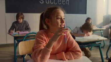 Ders sırasında elini kaldıran zeki çocuk. Soruya cevap veren sevimli bir öğrenci.