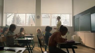 Öğrenciler sınıfta öğreniyor. Ders sırasında not defterlerine yazan zeki öğrenciler