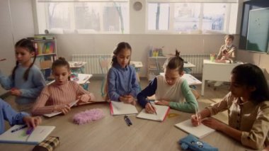 Öğrenciler sınıfta ders için hazırlanıyor. Öğretmen okulda derse başlıyor.