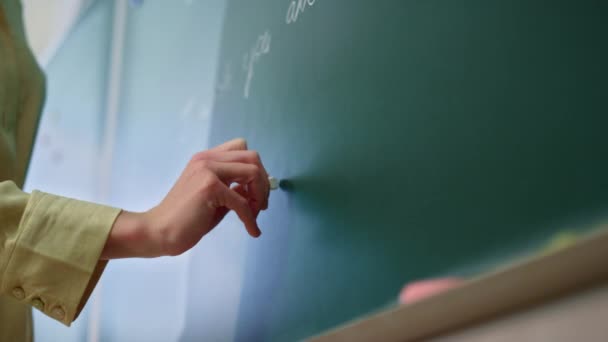 Nauczyciel rysuje na tablicy. Nauczyciel ręczne pisanie na tablicy — Wideo stockowe