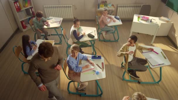 Grupo diverso de crianças tendo aula em sala de aula com professor — Vídeo de Stock