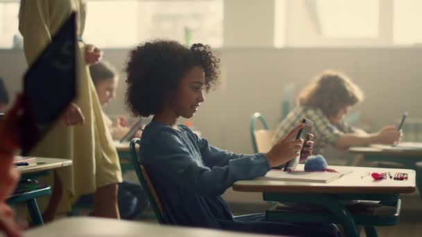 Dívka používající digitální tablet na hodině. Učitelka chodí ve třídě — Stock video