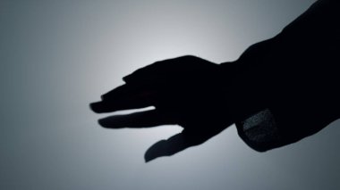 Sahne ışıkları altında kadın eli silueti. Kız hareket eden kol ve parmaklar.