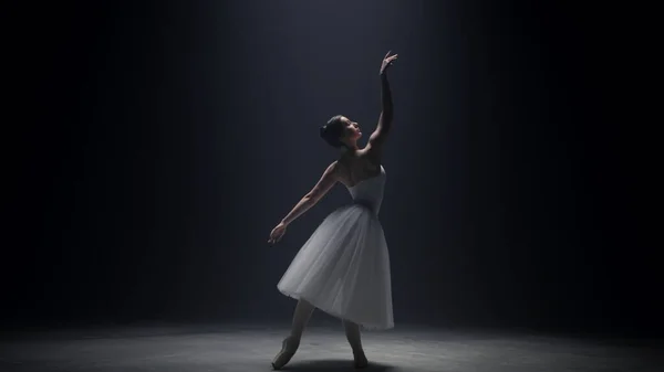 Ballerine flexible debout sous les projecteurs. Ballet danseur déplacer les mains sur scène — Photo