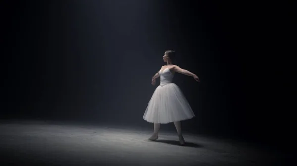 Jolie ballerine qui tourne sur la pointe des pieds. Danse de ballet sur scène. — Photo
