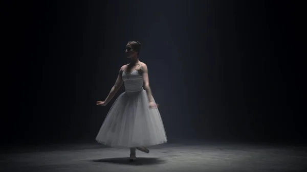 Bela bailarina dançando na ponta dos pés dentro de casa. Dançarina de balé ensaiando no palco — Fotografia de Stock