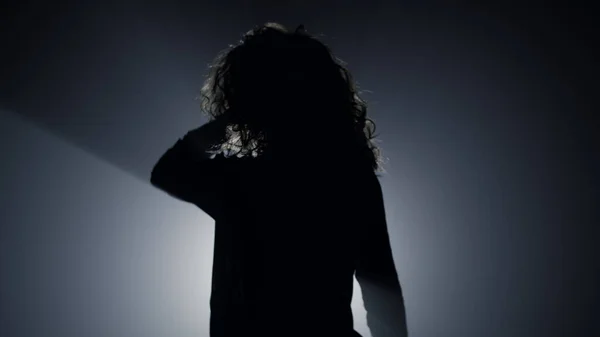 Silhouette szexi lány táncol a sötétben. Gyönyörű nő megható haj. — Stock Fotó