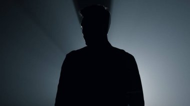 Siluet topçusu karanlıkta tabancayla el kaldırıyor. Suçlu silah taşıyor..