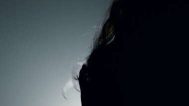 Siluet seksi manken, kafa içeride uçuşan saçlar. Güzel kız dans ediyor