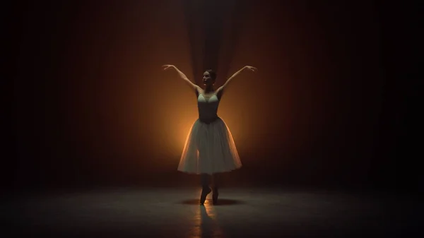 Bailarina flexível dançando na ponta dos pés no palco. Dançarina de balé usando saia tutu — Fotografia de Stock