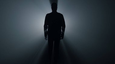 Karanlıkta yürüyen siluet adam. Erkek adam karanlıkta dümdüz gidiyor..