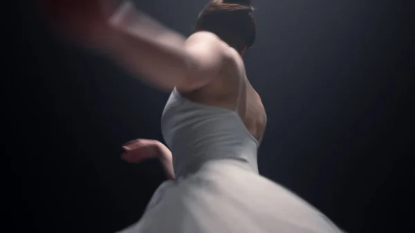 Bela dançarina de ballet a girar dentro de casa. Bailarina dançando no espaço escuro. — Fotografia de Stock
