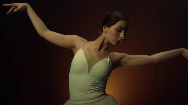 Mulher elegante dançando balé dentro de casa. Bailarina flexível mãos em movimento no ar. — Fotografia de Stock