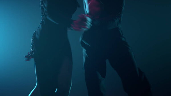 Professional dancers performing latin program in darkness. Passionate couple dancing in backlight background. Unknown ballroom partners showing dance movement indoors.