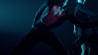 Balo çifti karanlık uzayda gösteri yapıyor. Dansçılar içeride Latince dans ediyorlar.