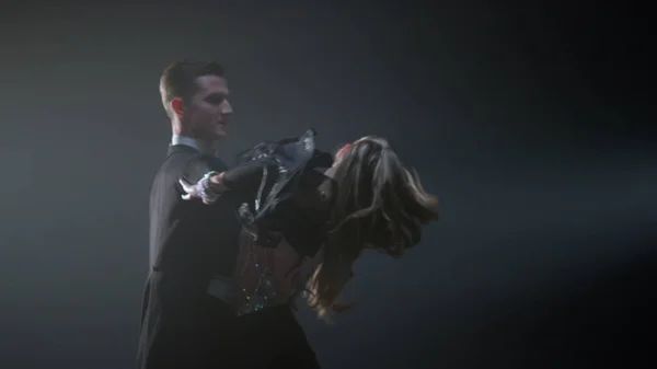 Pareja de baile de salón girando en el espacio oscuro. Hombre y mujer elegantes bailando. — Foto de Stock