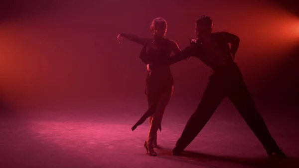 Passionate couple bending during dance indoors. Ballroom partners dancing