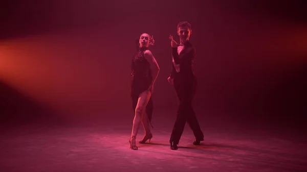 Homem e mulher lindos dançando no palco iluminado. Casal de dança. — Fotografia de Stock